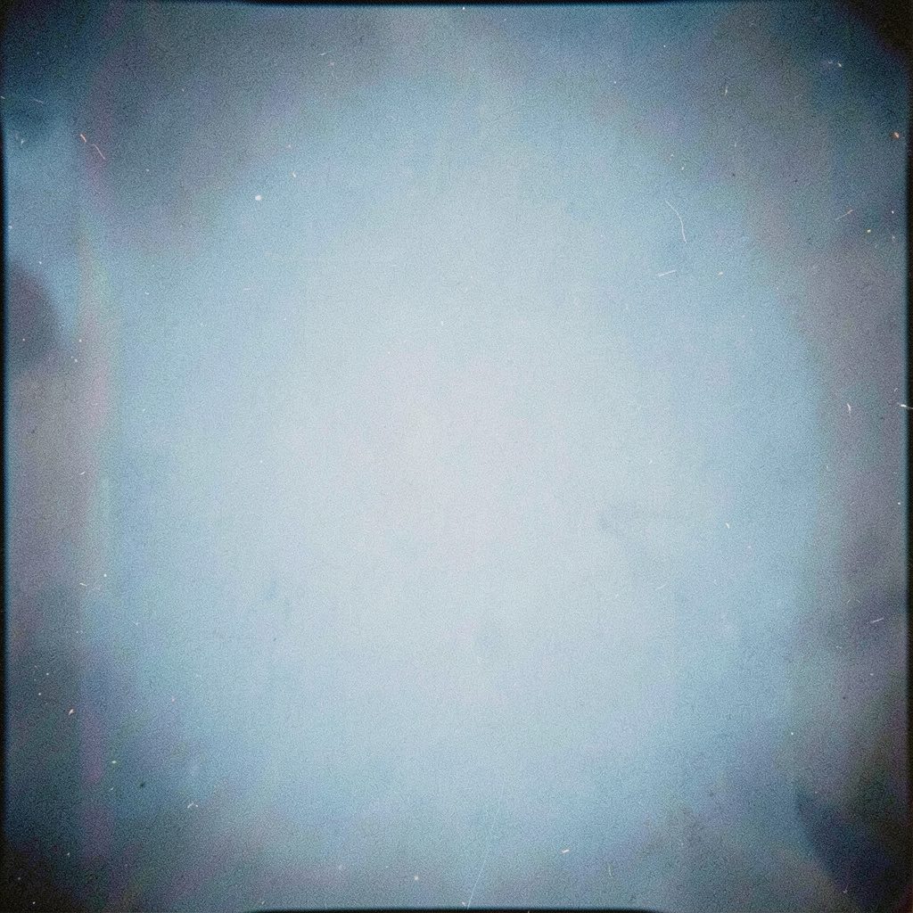 Documento d'archivio fotografato su sfondo neutro in luce morbida, colori neutri e pellicola sgranata